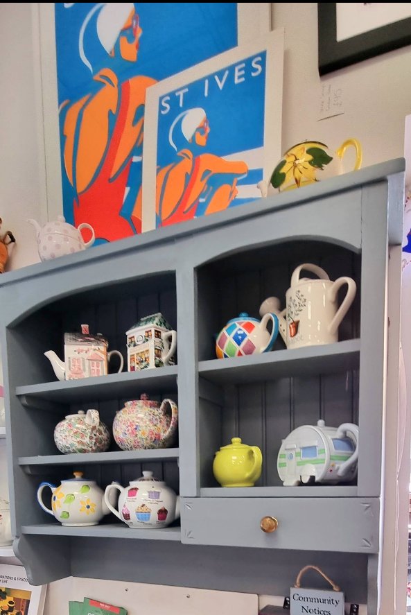 Colourful teapots displayed on a shelf at Cafe Art